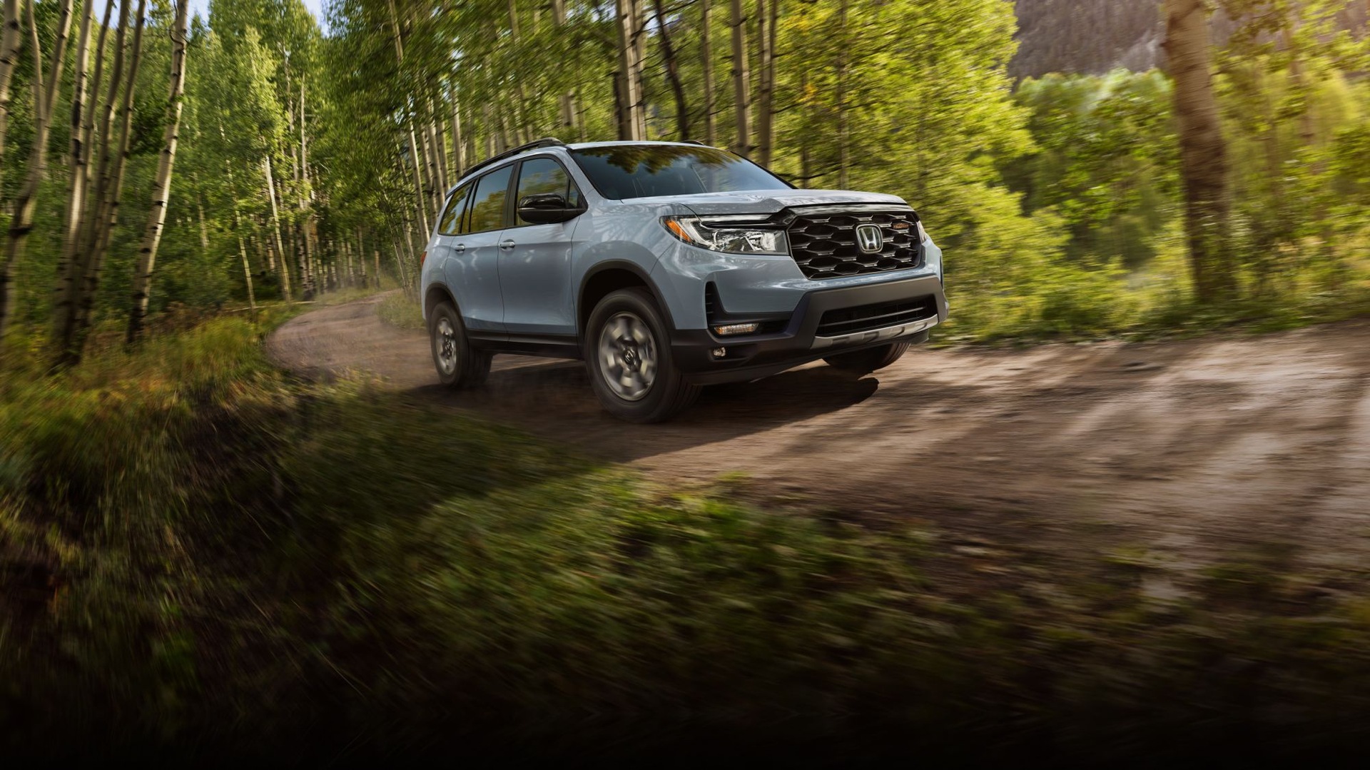 2024 Honda Passport in action on a dirt road in nature