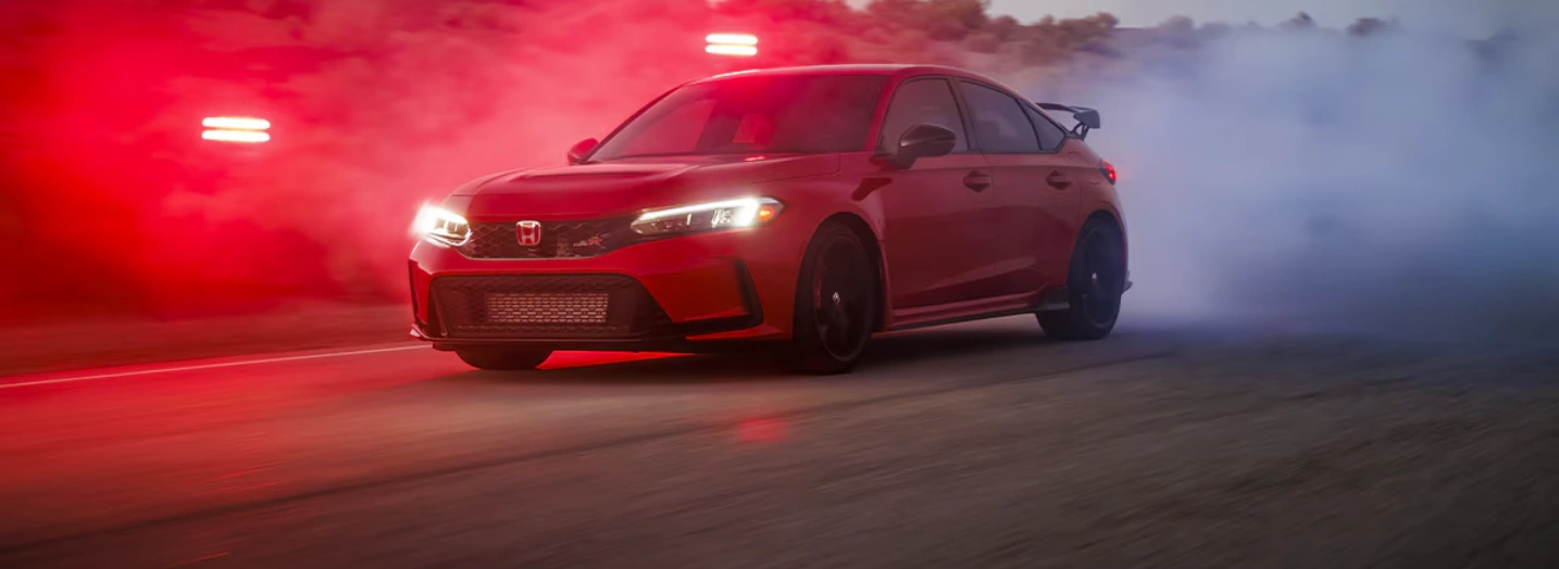 2025 Honda Civic Type R on track, winner of the 2025 Car and Driver Award, with smoke effects and red lighting.