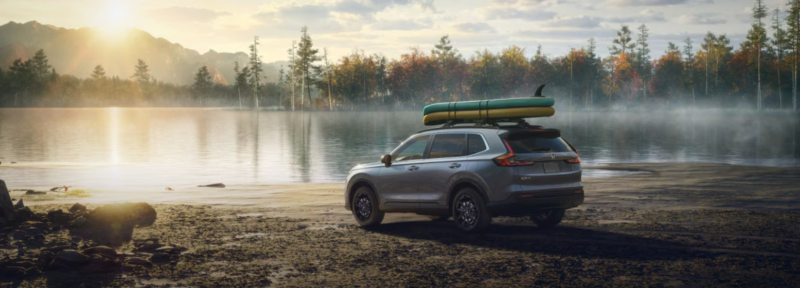 2026 Honda CR-V parked by a lake at sunrise, with boards mounted on the roof.